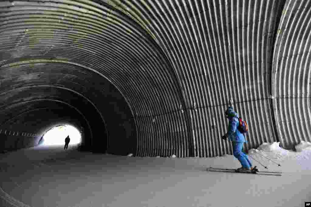 Olympic workers ski through a tunnel on the way to the Alpine ski course ahead of the 2014 Sochi Winter Olympics, Feb. 4, 2014.