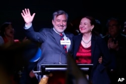 Alejandro Guillier, left, of the Nueva Mayoria coalition celebrates with his wife, Maria Cristina Farga, early results that place him second in the presidential election, in Santiago, Chile, Nov. 19, 2017.