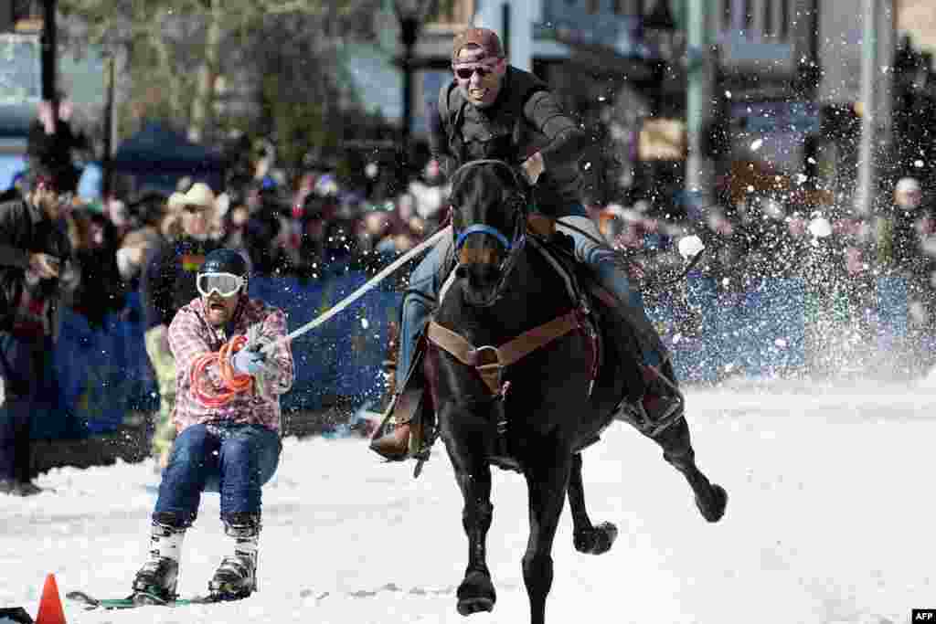 Rider Eric Mikkelson and skier Jason Dahl race to the finish line during the 70th annual Leadville Ski Joring weekend competition in Leadville, Colorado, March 3, 2018.