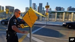 Un officier de police met en place ruban jaune de fermer l'extérieur de l'école d'Edouard Roybal High School à Los Angeles , le mardi matin , le 15 déc 2015.