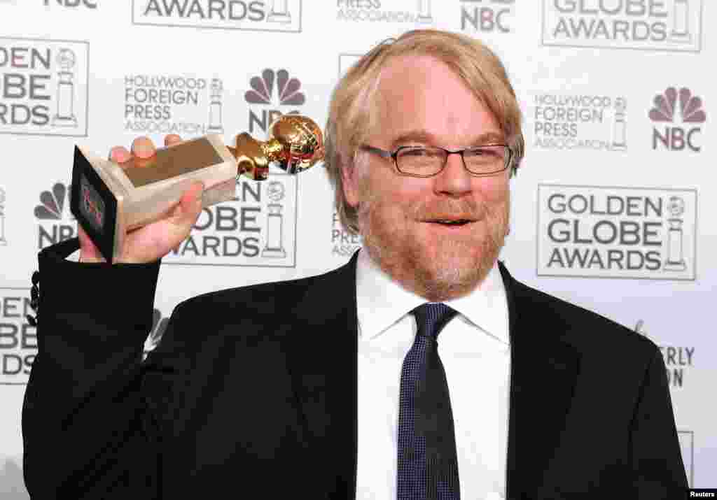 Philip Seymour Hoffman berpose dengan piala aktor terbaik untuk film drama bagi film &quot;Capote&quot; pada Golden Globe Awards 2006.