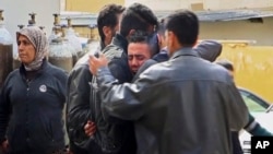 Men grieve outside a hospital following Turkish airstrikes on the Syrian Kurdish enclave of Afrin, northwestern Syria, Feb. 14, 2018. Nearly a month into Turkey's offensive in Afrin, hundreds of thousands of Syrians are hiding from bombs and airstrikes, trapped while Turkish troops and their allies are bogged down in fierce ground battles against formidable opponents.