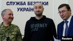 Russian journalist Arkady Babchenko (C), who was reported murdered in the Ukrainian capital on May 29, Ukrainian Prosecutor General Yuriy Lutsenko (R) and head of the state security service (SBU) Vasily Gritsak attend a news briefing in Kyiv, Ukraine May 