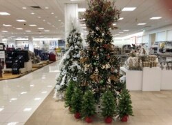 A display of Christmas trees stands next to holiday knick-knacks on display in a Macy's department store Thursday, Oct. 1, 2020, in northeast Denver.