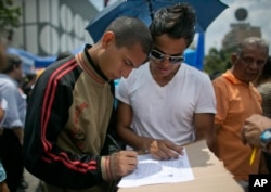A man signs a petition to initiate a recall referendum against Venezuela's President Nicolas Maduro in Caracas, April 27, 2016.