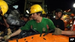 The body of one of two miners recovered on 21 Oct 2010 is loaded onto a truck