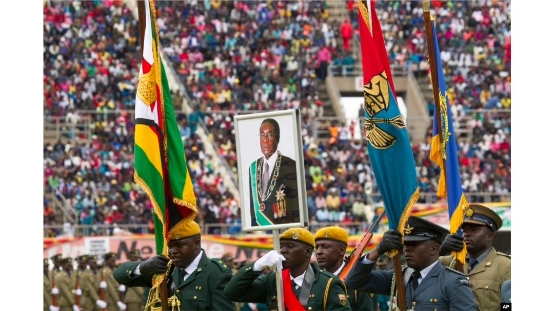 Soldiers carry a portrait of Zimbabwe's President Robert Mugabe during the country's 37th Independence celebrations in Harare, April, 18, 2017.