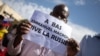 FILE - A man holds up a sign reading "Down with Emmanuel Macron, long live Russia," during a rally in Bamako, Mali, Jan. 14, 2022, against former colonial power France, which still maintains a military presence in Mali.
