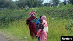 Internally displaced people wait for help at a rural area after fighting broke out, near the Blue Nile state capital al-Damazin, Sudan.