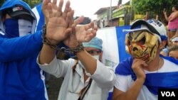 Trabajadores de salud muestran sus manos esposadas como protesta durante una manifestación en la ciudad de León, Nicaragua. Octubre 18, 2018.