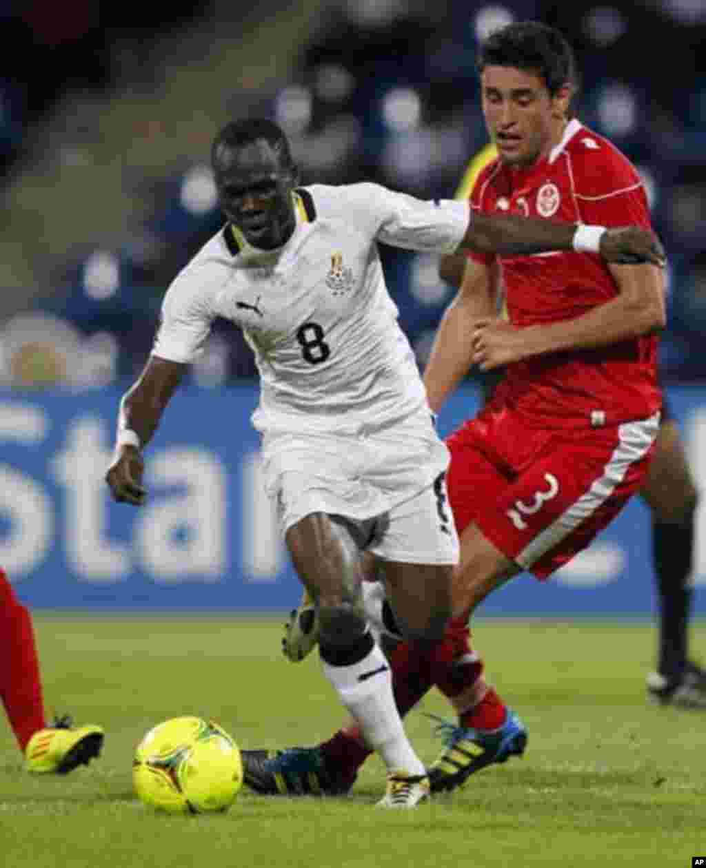 Ghana's Emmaneul Badu Agyemang (L) fights for the ball with Tunisia's Karim Haggui during their African Nations Cup quarter-final soccer match at Franceville stadium February 5, 2012.