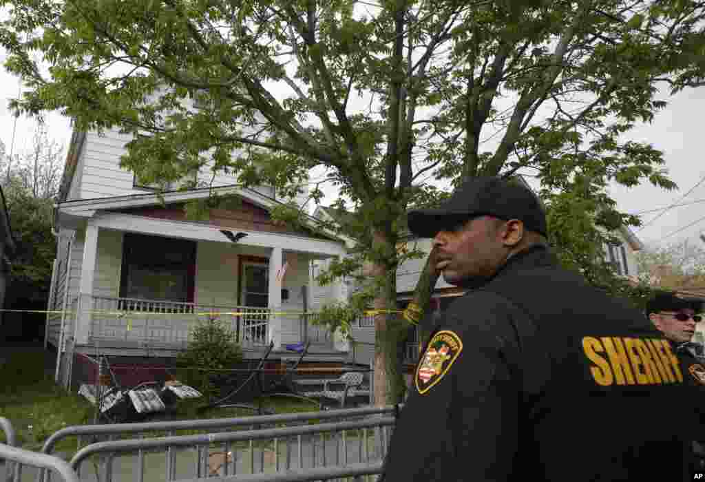 Zamjenik &scaron;erifa pred kućom iz koje su spa&scaron;ene tri žene koje su nestale prije deset godina, u Clevelandu, 7. maja 2013.