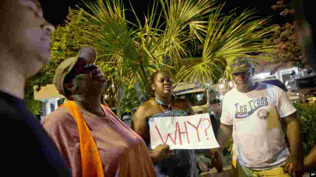 Surreace Cox, du nord de Charleston, en Caroline du Sud, tient une pancarte lors d&#39;une veillée de prière sur la rue de l&#39;église AME Emanuel jeudi matin 18 juin 2015 suite à une fusillade mercredi soir à Charleston.