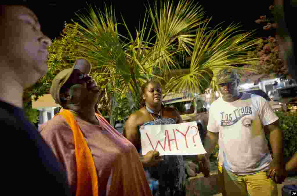 Surreace Cox dari North Charleston, S.C. mengikuti doa bersama di dekat Gereja Emanuel AME Kamis pagi (18/6) menyusul penembakan di Charleston malam sebelumnya. ​(AP/David Goldman)