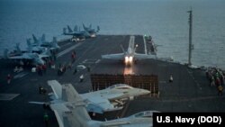 ເຮືອບົນລົບ F/A-18E ຈາກຝູງບິນໂຈມຕີ 137​ ພວມບິນຂຶ້ນ ຈາກກຳປັ່ນບັນທຸກເຮືອບິນ USS Carl Vinson ຢູ່ທະເລຈີນໃຕ້. (12 ເມສາ 2017)
