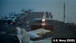 FILE - An F/A-18E from the Strike Fighter Squadron 137 takes off from the aircraft carrier USS Carl Vinson flight deck in the South China Sea, April 12, 2017.