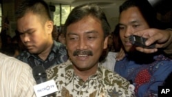 Indonesian Sports and Youth Minister Andi Alfian Mallarangeng is mobbed by the press after announcing his resignation in Jakarta, Indonesia, Dec. 7, 2012. 