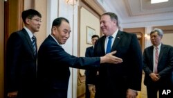  Mike Pompeo (Amerîka) yê duyê ji milê (rastê) Kim Yong Chol (Koreya Bakurd) yê duyê ji milê (çepê) 