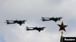 Russian Tu-99 bombers fly in formation during rehearsals for the Victory Day military parade, with a tower of the Kremlin in the foreground, in Moscow, May 3, 2014.