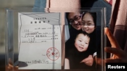 人权律师王全璋的妻子李文足2018年12月17日向媒体展示逮捕令和家庭照（路透社）