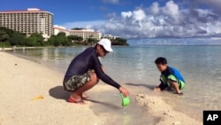 Kenji Kikuchi plays with his son Hideki in Ypao Beach, Tumon, Guam, Aug. 14 2017. Kikuchi was aware of the threat from reading the local newspaper and was a little worried. 
