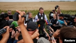 FILE - An OSCE monitor speaks to reporters near Grabovo, Donetsk region, eastern Ukraine, July 19, 2014. Coverage of the conflict in eastern Ukraine between government forces and pro-Russia rebels has been a delicate task for many Ukrainian journalists.