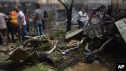 In this photo released by the Syrian official news agency SANA, Syrian citizens and firefighters gather at the scene where one of rockets hit the Dubeet hospital in the central neighborhood of Muhafaza in Aleppo, Syria, Tuesday, May 3, 2016. 