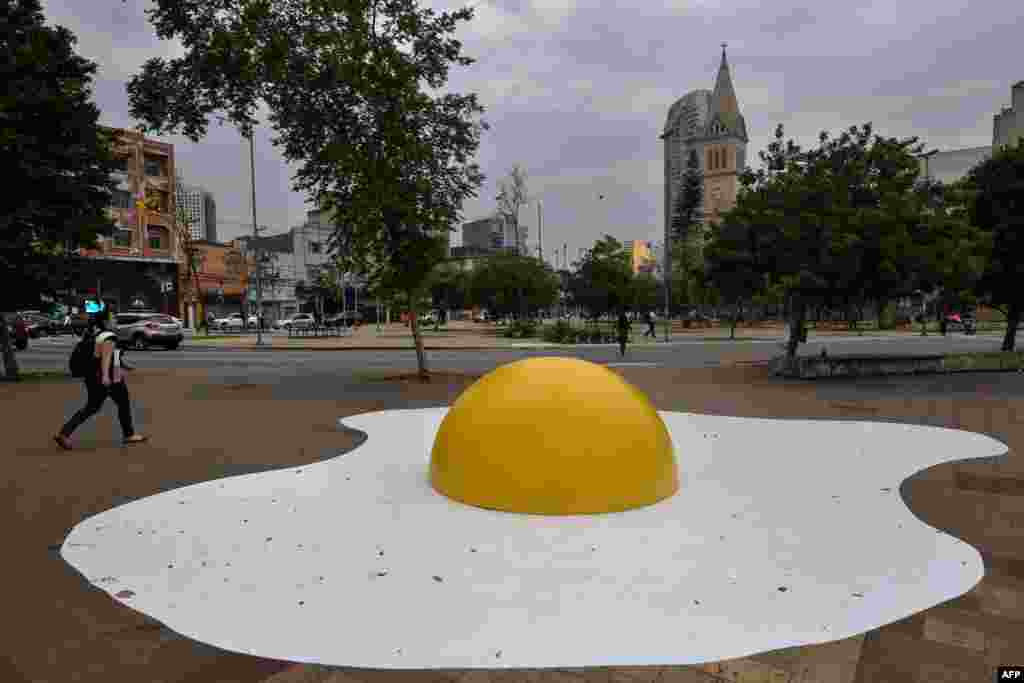 A person walks by an urban intervention called &quot;Eggcident&quot; — a warning for the severity of global warming — by Dutch artist Henk Hofstra during the annual &quot;Virada Sustentavel SP&quot; event, in Sao Paulo, Brazil.