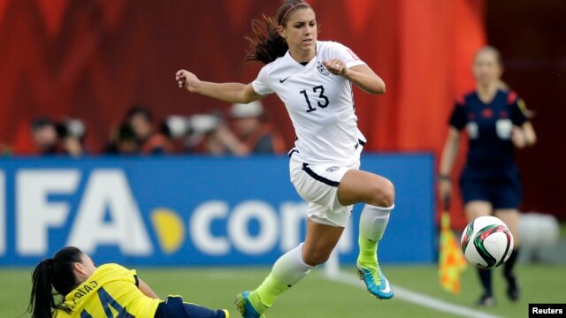 La estadounidense Alex Morgan (13) supera la marca de la colombiana Nataly Arias durante el juego del Mundial femenino en Edmonton, Alberta, en el que Estados Unidos pasó a cuartos de final.