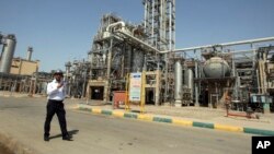 FILE - In this 2011 file photo, an Iranian security guard stands at the Maroun Petrochemical plant at the Imam Khomeini port, southwestern Iran. U.S. companies are interested in developing markets in Iran.