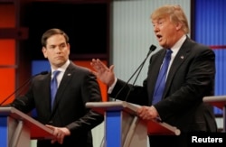 Republican U.S. presidential candidate Marco Rubio listens as rival candidate Donald Trump speaks at the U.S. Republican presidential debate in Detroit, Michigan, March 3, 2016.