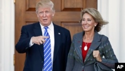  President-elect Donald Trump, left, and Betsy DeVos, right, pose for photographs at Trump National Golf Club Bedminster's clubhouse in Bedminster, N.J.