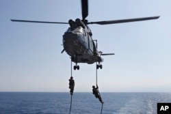 Lebanese army soldiers rappel down from a helicopter onto the deck of the Brazilian warship UNIAO, part of the UNIFIL Maritime force.