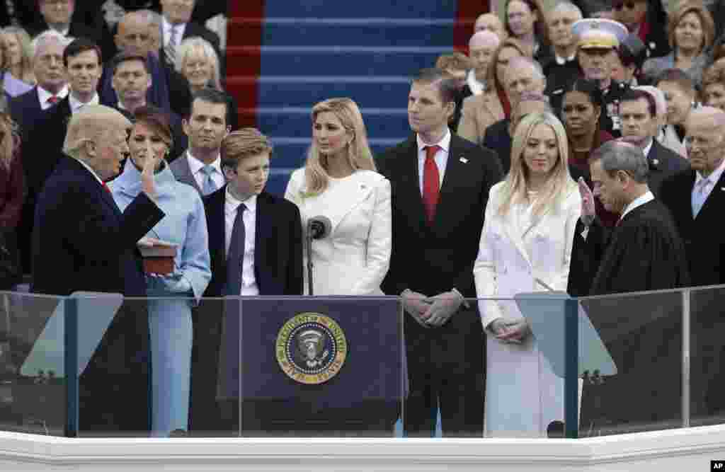 Donald Trump diambil sumpahnya sebagai Presiden AS ke-45 oleh Ketua Mahkamah Agung John Roberts sementara istrinya Melania Trump dan keluarganya menyaksikannya di Gedung Capitol di Washington, 20 Januari 2017.