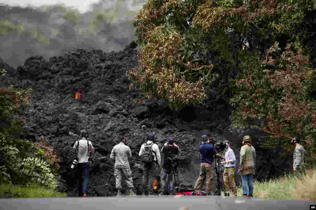 Para awak media mengabadikan &quot;tembok&quot; lahar saat memasuki Samudera Pasifik di dekat Pahoa, Hawaii (20/5).