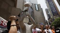 Pro-democracy protesters display a goddess of democracy statue during a demonstration in Time Square in downtown Hong Kong, May 28, 2011, as they urge people to attend an upcoming protest on June 4.