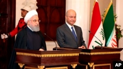 Iraqi President Barham Salih, right, and Iranian President Hassan Rouhani hold a press conference at Salam Palace in Baghdad, Iraq, March 11, 2019.