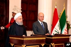 Iraqi President Barham Salih, right, and Iranian President Hassan Rouhani hold a press conference at Salam Palace in Baghdad, Iraq, March 11, 2019.