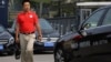 A man walks past Mercedes-Benz cars parked outside the dealer sales showroom in Beijing, China, Aug. 18, 2014. 