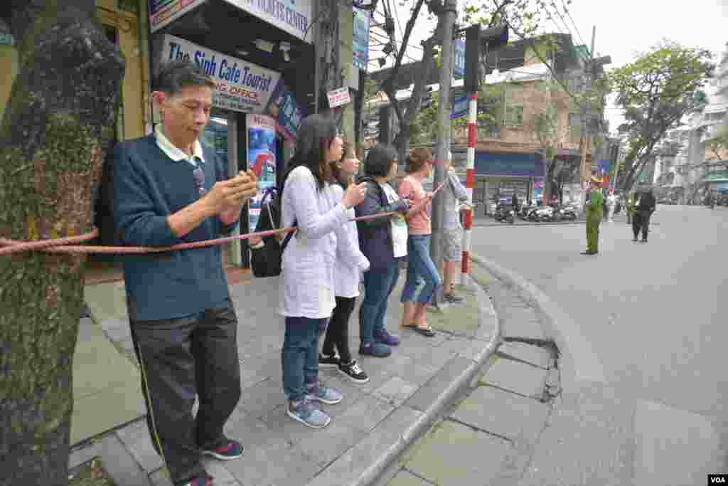 하노이 시민들이 미북 정상회담장에서 숙소로 돌아가는 트럼프 대통령의 차량을 찍기 위해 스마트폰을 든 채 기다리고 있다.