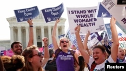 27일 미국 워싱턴의 대법원 건물 앞에서 낙태 반대론자들이 텍사스 주 낙태법 위헌 판결에 환호하고 있다.