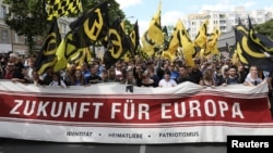FILE - Protestors carry a banner that reads: "Future for Europe" during a demonstration of the far-right Identitarian Movement (Identitaere Bewegung) in Berlin, June 17, 2017.