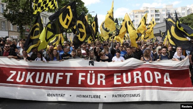 FILE - Protestors carry a banner that reads: "Future for Europe" during a demonstration of the far-right Identitarian Movement (Identitaere Bewegung) in Berlin, June 17, 2017.