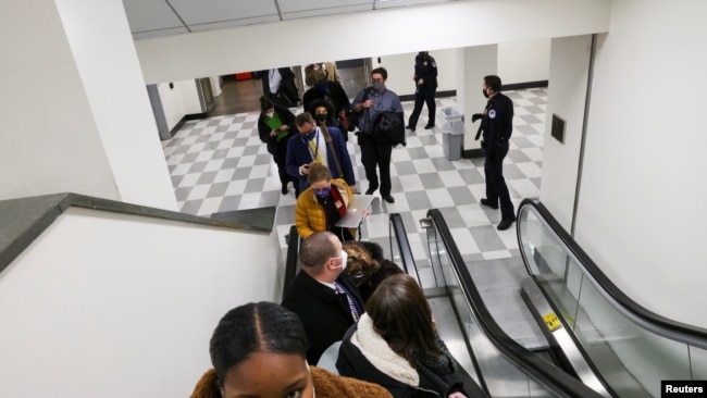 U.S. Capitol Police evacuate journalists and House press staff members from the Capitol to a connected office building, in Washington, U.S., January 6, 2021.