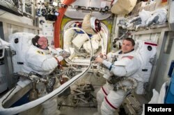 FILE - NASA astronauts Reid Wiseman, right, and Barry Wilmore work inside the International Space Station on October 1, 2014.