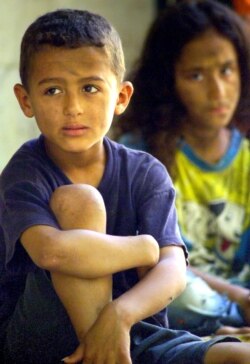 Anak-anak tunawisma Mesir duduk di trotoar di sebuah jalan di Kairo, 20 Agustus 2004. (Foto: Reuters)