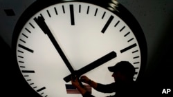 Dave LeMote menggunakan kunci pas allen untuk menyesuaikan jarum jam menara stainless steel di Electric Time Company, Inc. di Medfield, Massachusetts. Musim dingin telah tiba di AS dengan berakhirnya waktu daylight saving pada Minggu (7/11) hampir di seluruh wilayah AS.(Foto: AP)