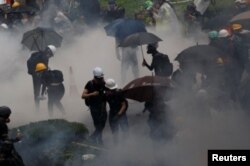 AManifestantes contra la ley de extradición están rodeados de gases lacrimógenos durante los enfrentamientos con la policía en Tsuen Wan en Hong Kong, el 25 de agosto de 2019.