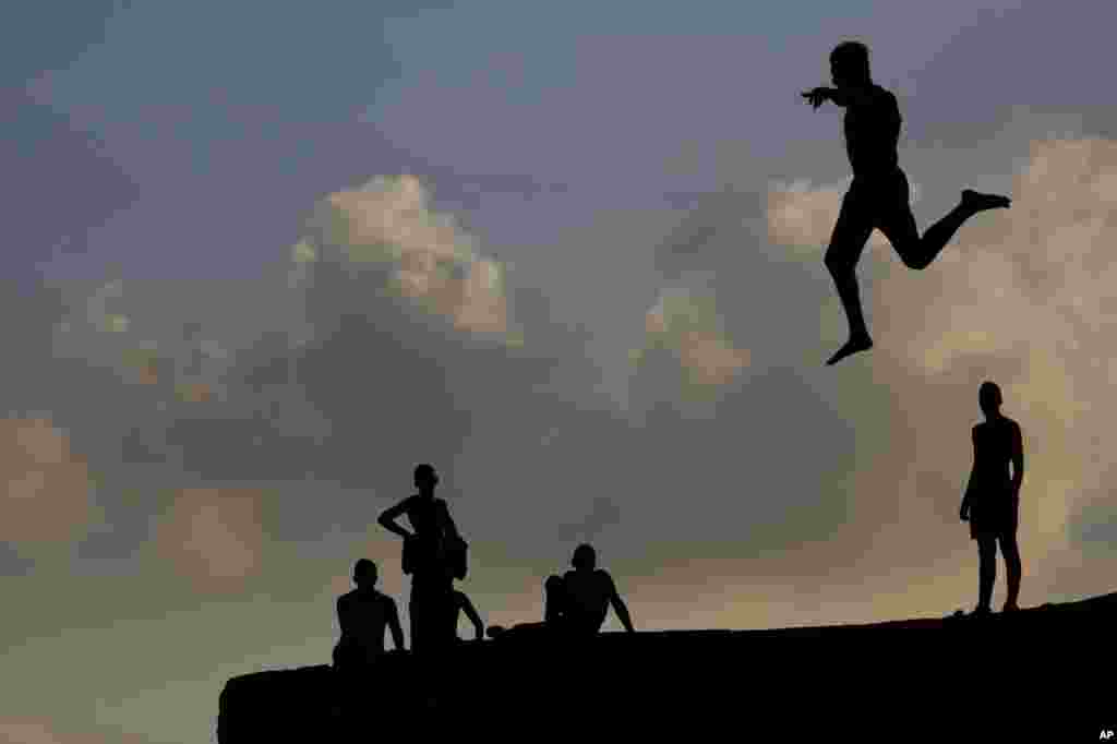 Israeli Arab boys jump into the Mediterranean Sea from the ancient wall surrounding the old port city of Acre, on the first day of the Eid al-Adha Muslim holiday, Israel, Aug. 21, 2018.