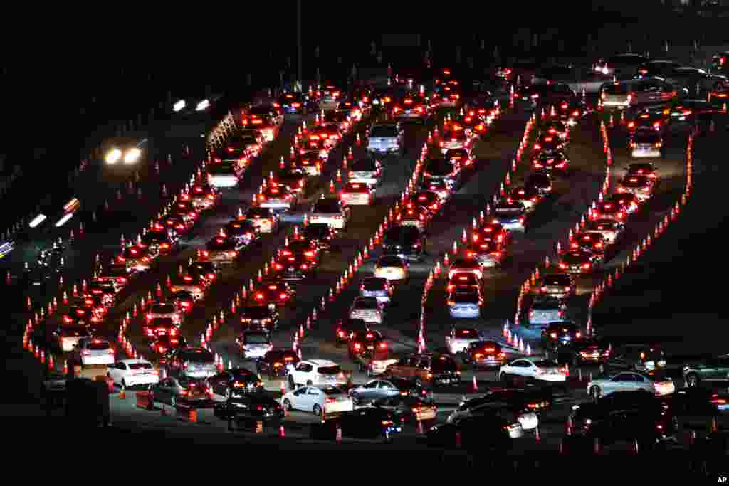 Motorists line up to take a coronavirus test in a parking lot at Dodger Stadium, Jan. 4, 2021, in Los Angeles.